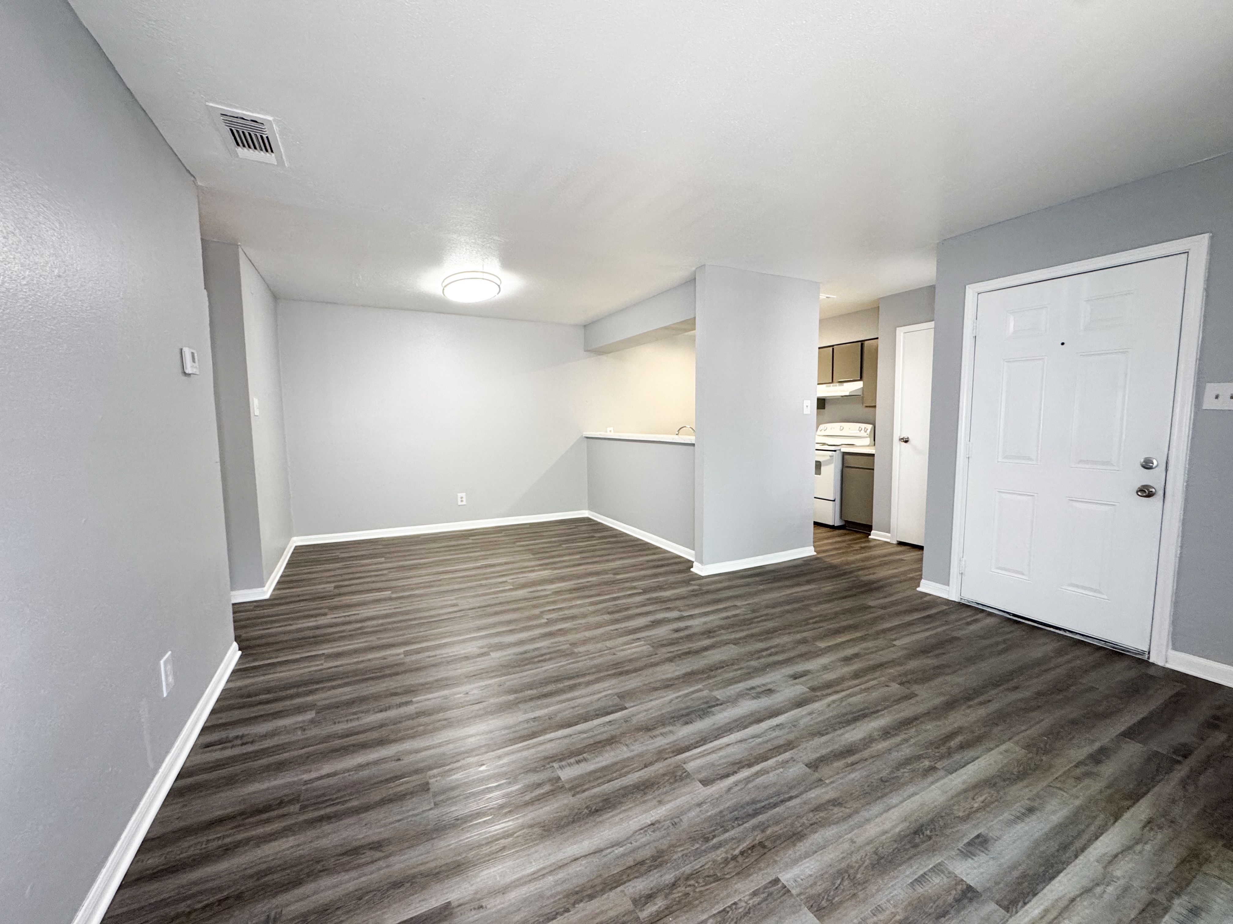 A room with wooden flooring and white walls.