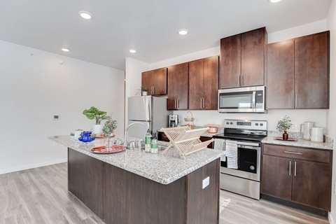 A kitchen with brown cabinets and a granite countertop.