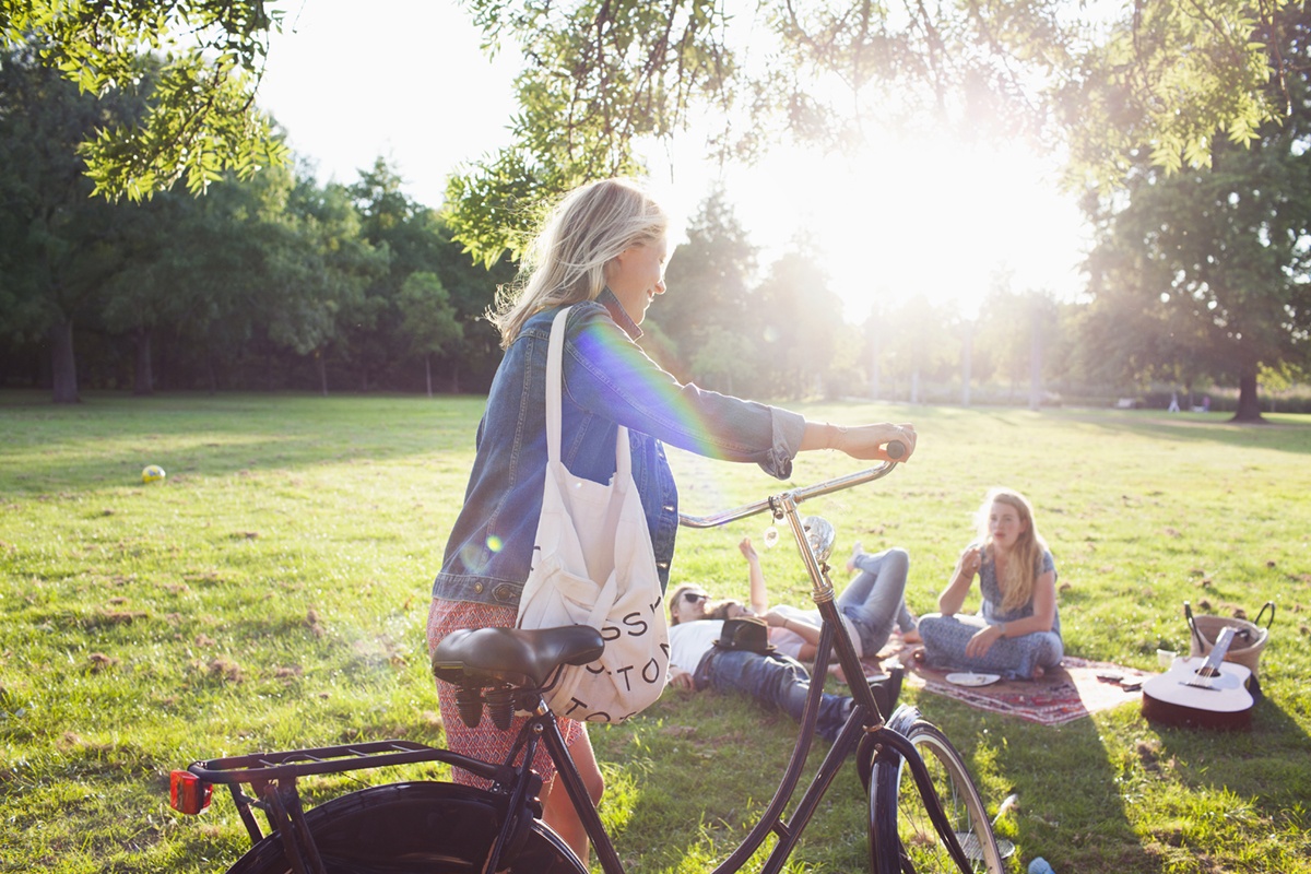 A woman is riding a bicycle in a park.