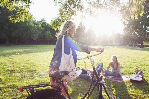 A woman is riding a bicycle in a park.
