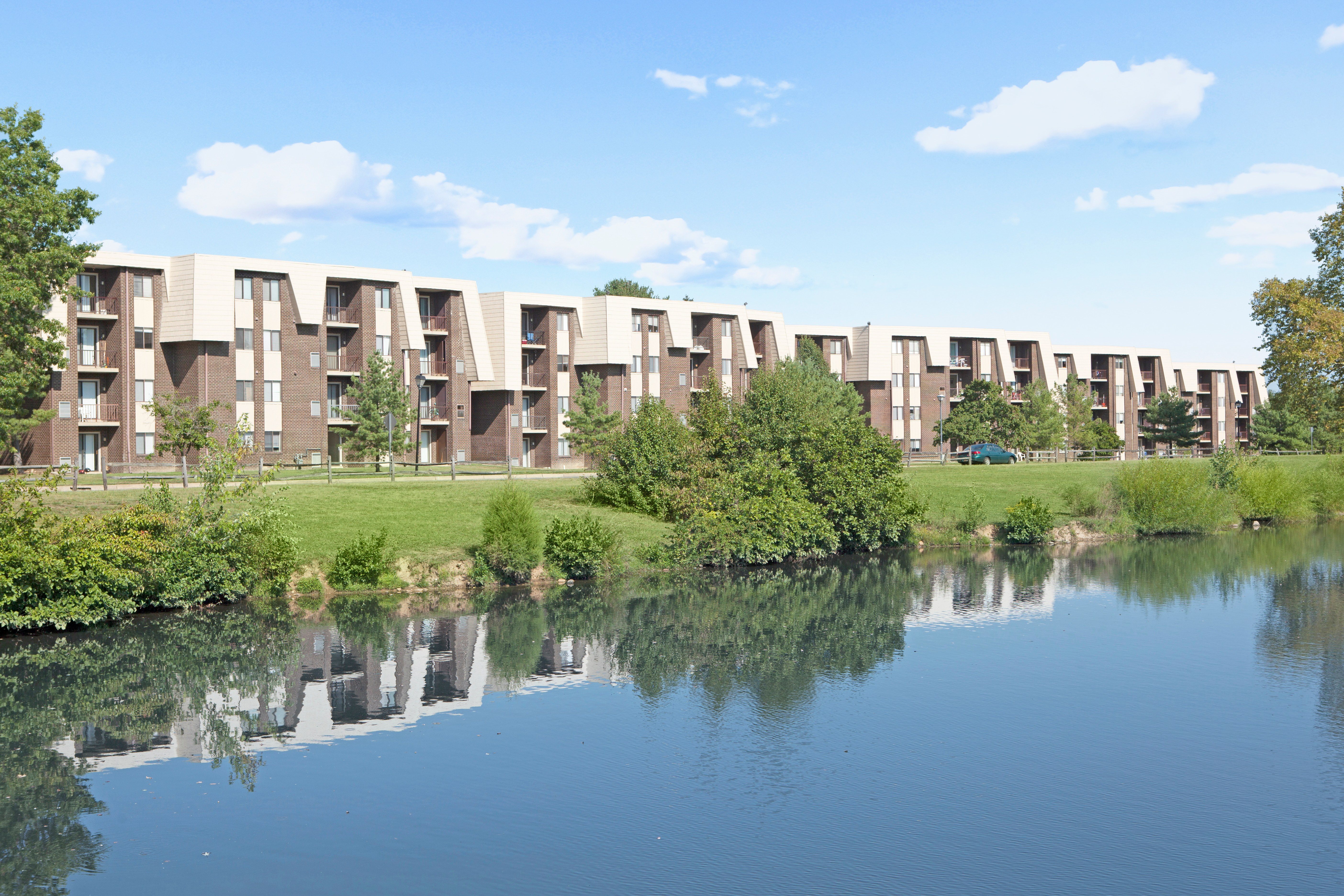 A row of apartment buildings are reflected in the water.