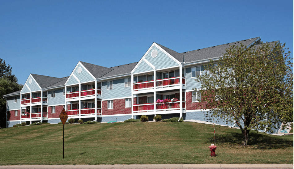 an apartment building on a hill with a fire hydrant