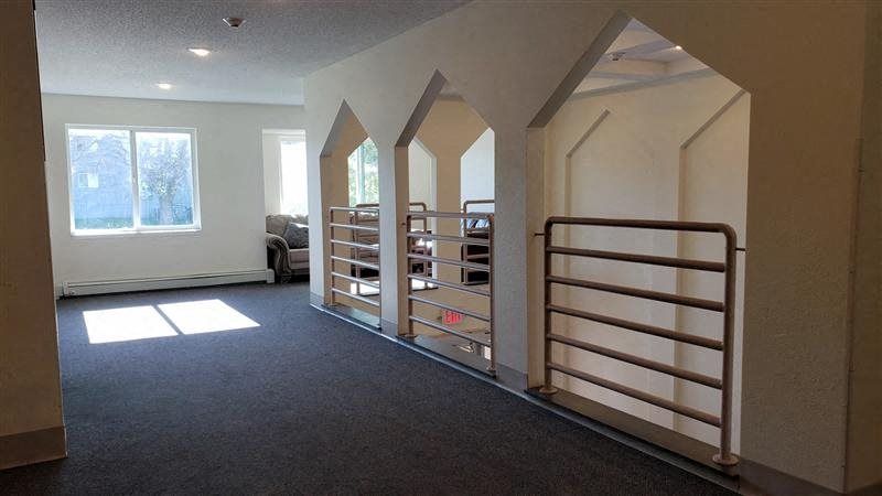 an empty room with a staircase and a book shelf