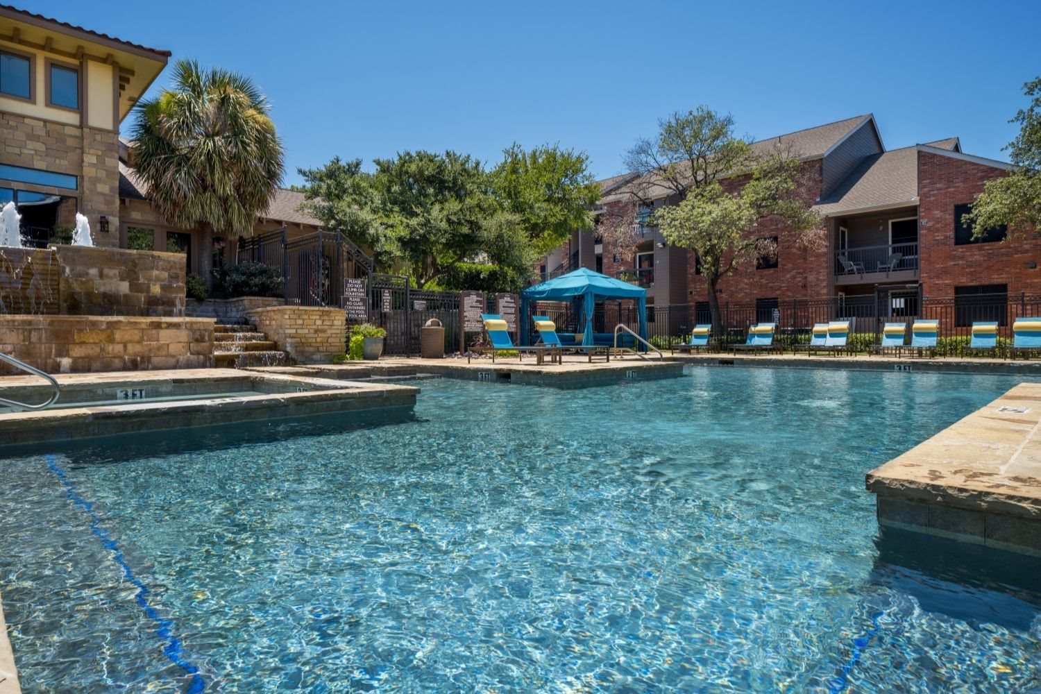 Sparkling swimming pool with shaded umbrella seating and poolside loungers.