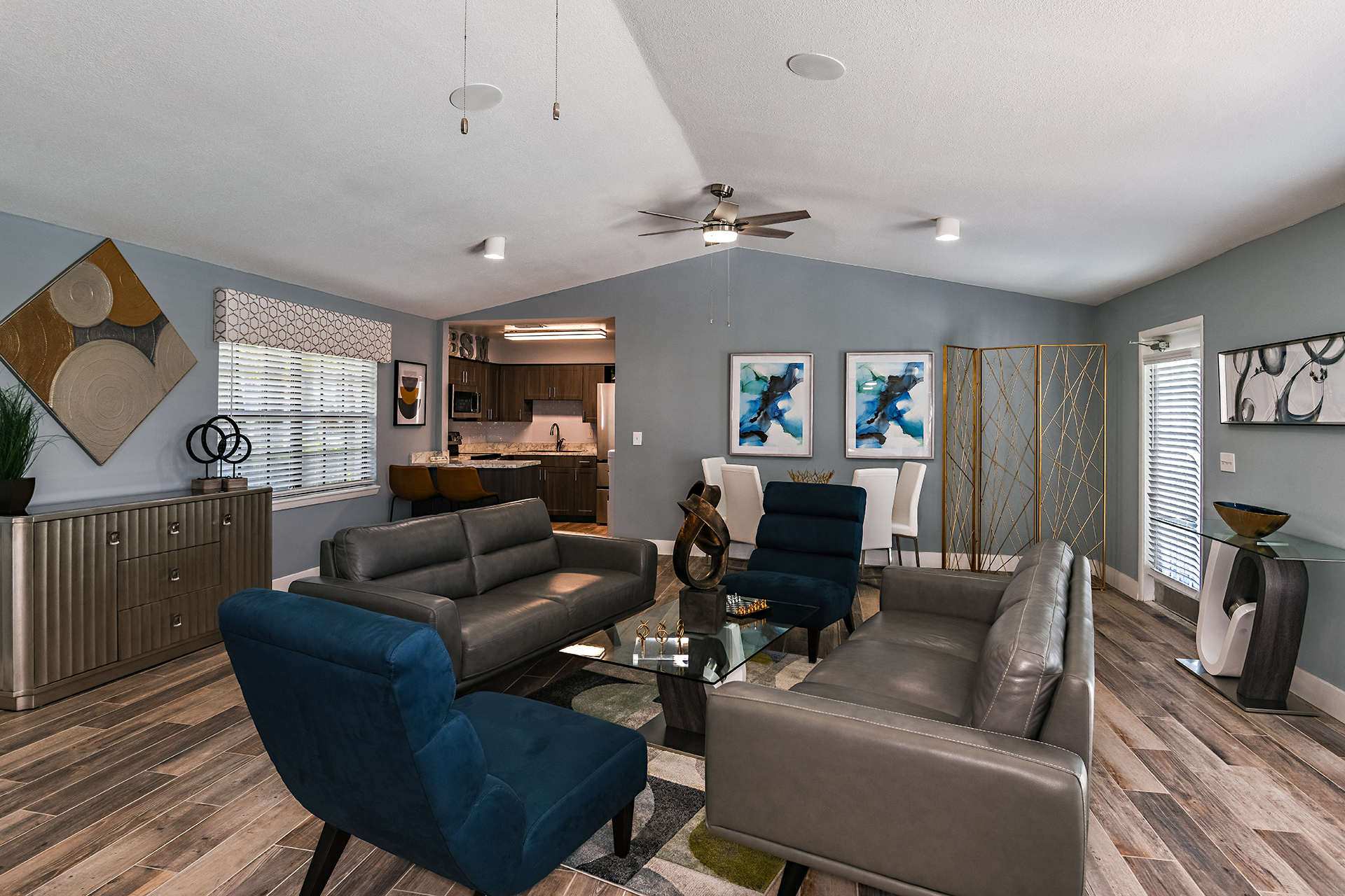 Side view of Brookside Manor renovated and redecorated clubhouse lounge with comfortable couches and lounge chairs, tastefully decorated with inspired art pieces, with wood plank flooring