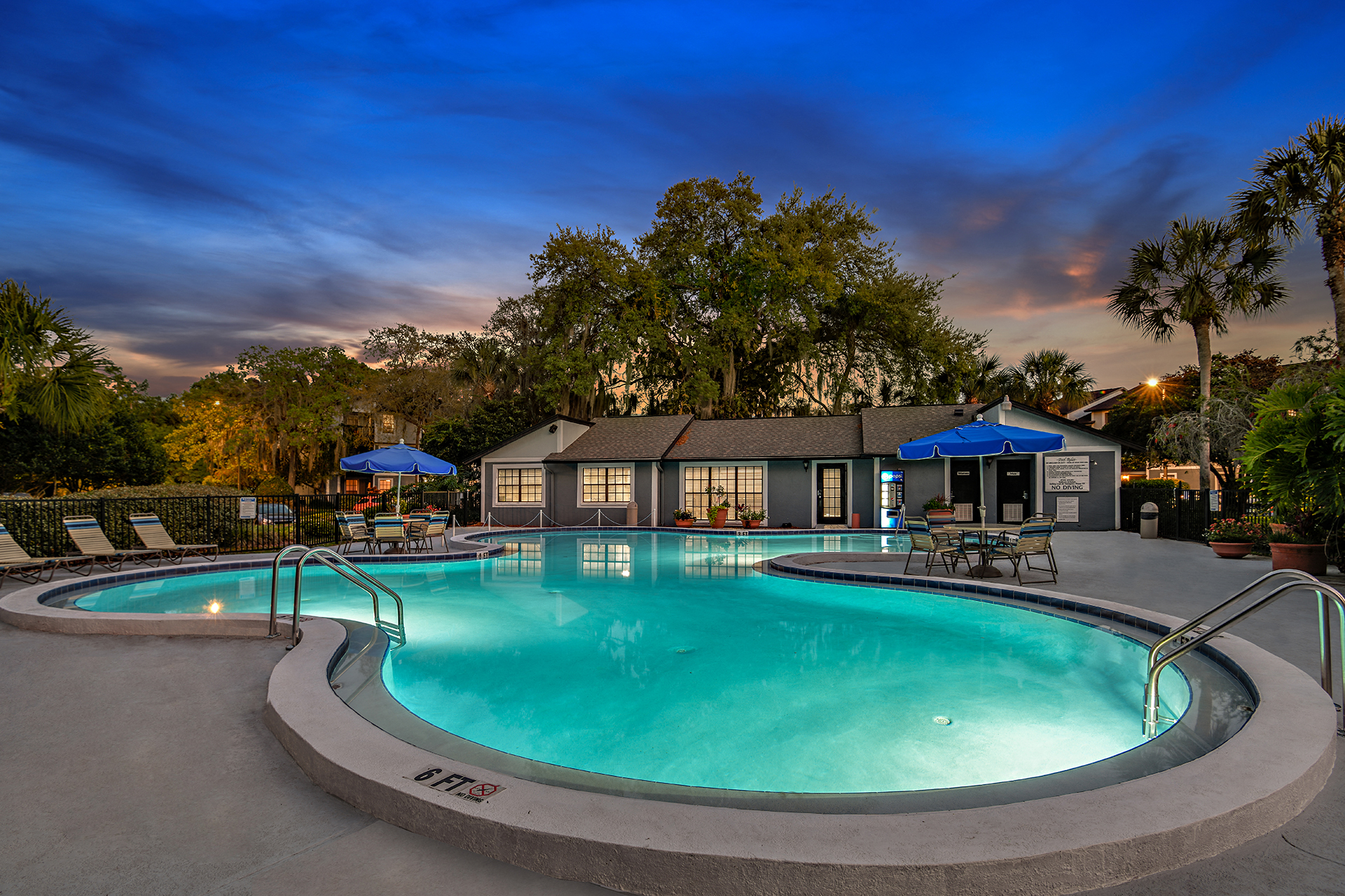 View of Brookside Manor Pool at Sunset with a dark blue sky and shimmering pool lights