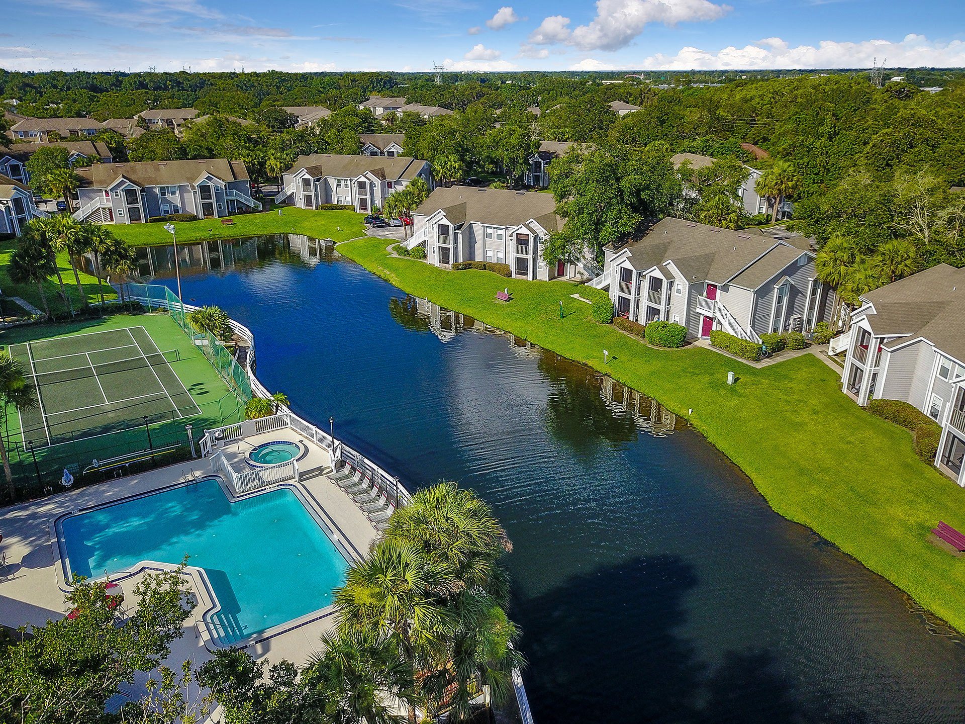 a large body of water with houses and a tennis court