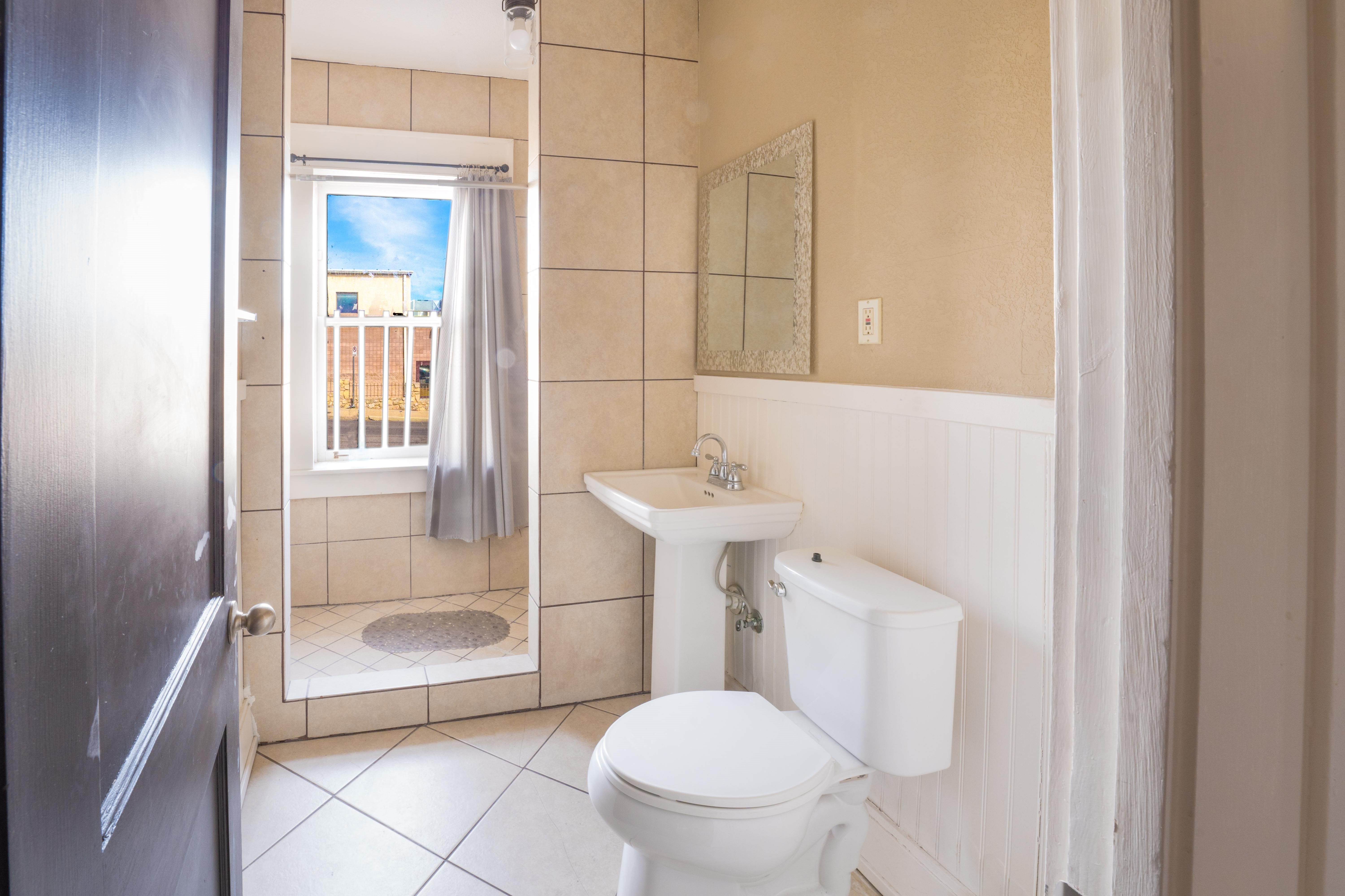 A bathroom with a toilet, sink, and shower.