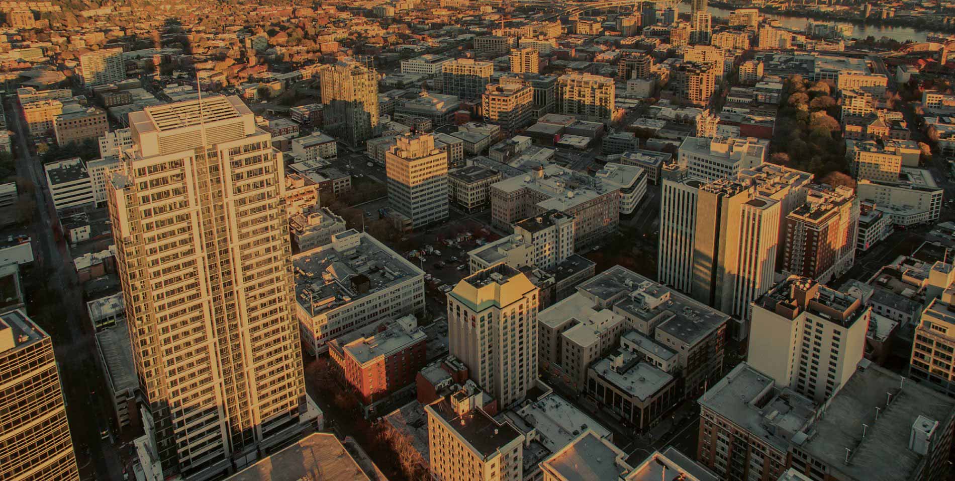 The sun casts its glow as we soar high above downtown Portland, Oregon.