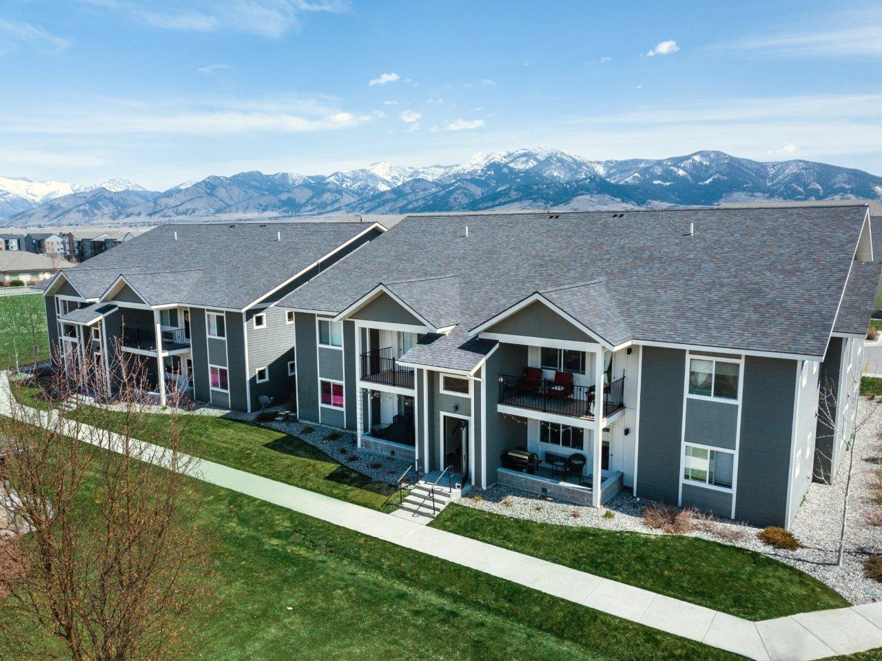 an aerial view of three houses with mountains in the background at Madison Park, Bozeman, MT