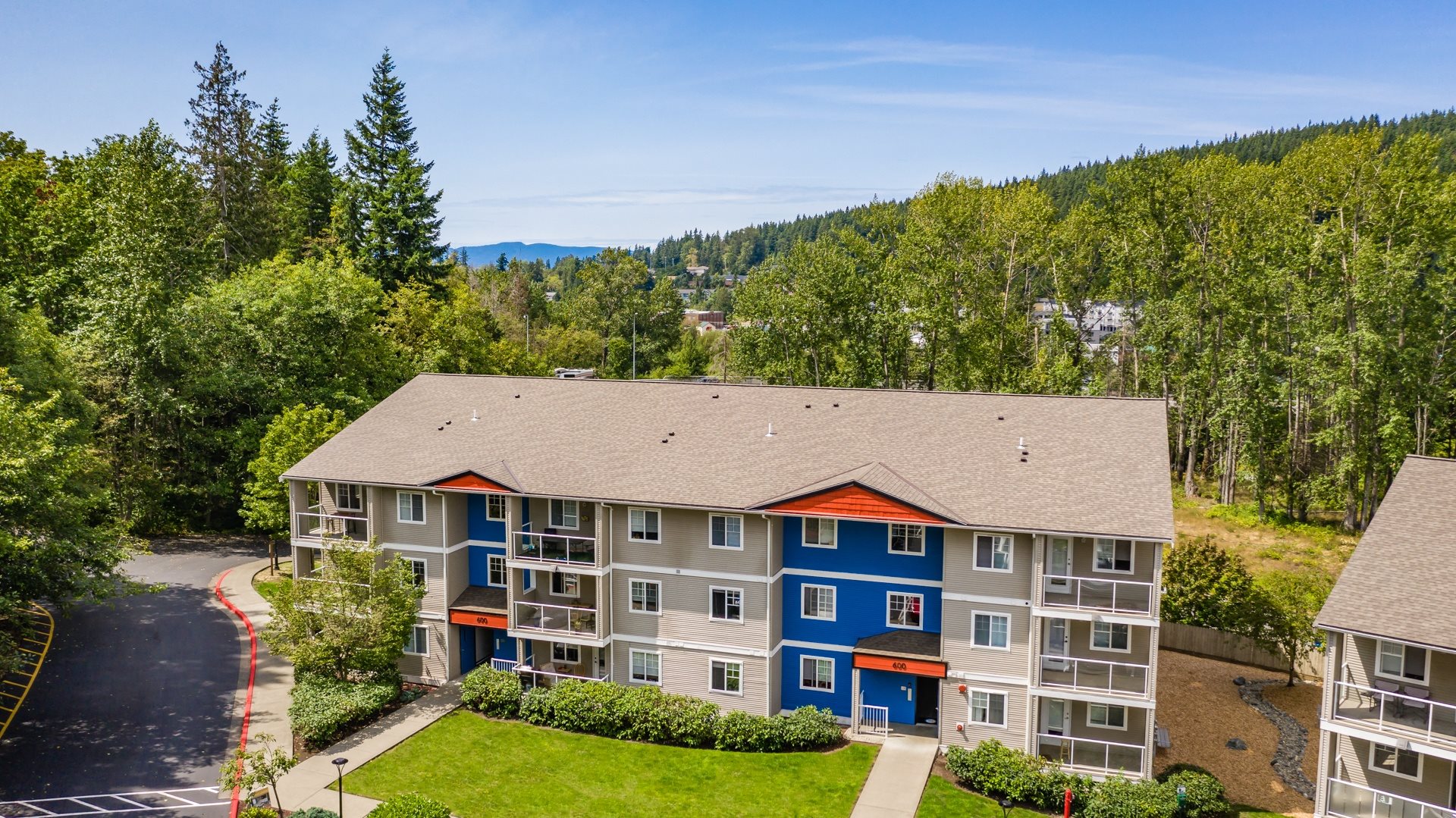 aerial view of the building with trees and mountains in the background
