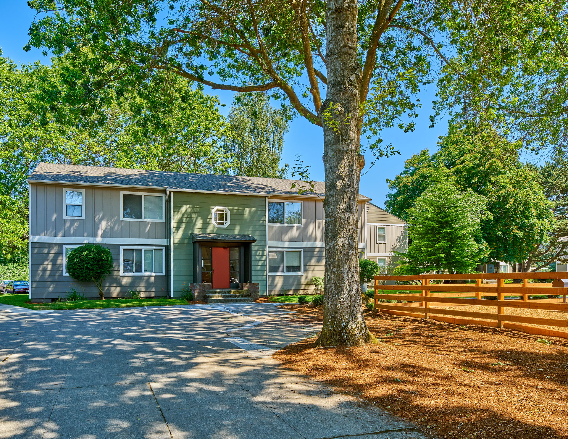 the front of the community building with a large tree in the middle of the driveway.at Woodhaven, Everett, 98203