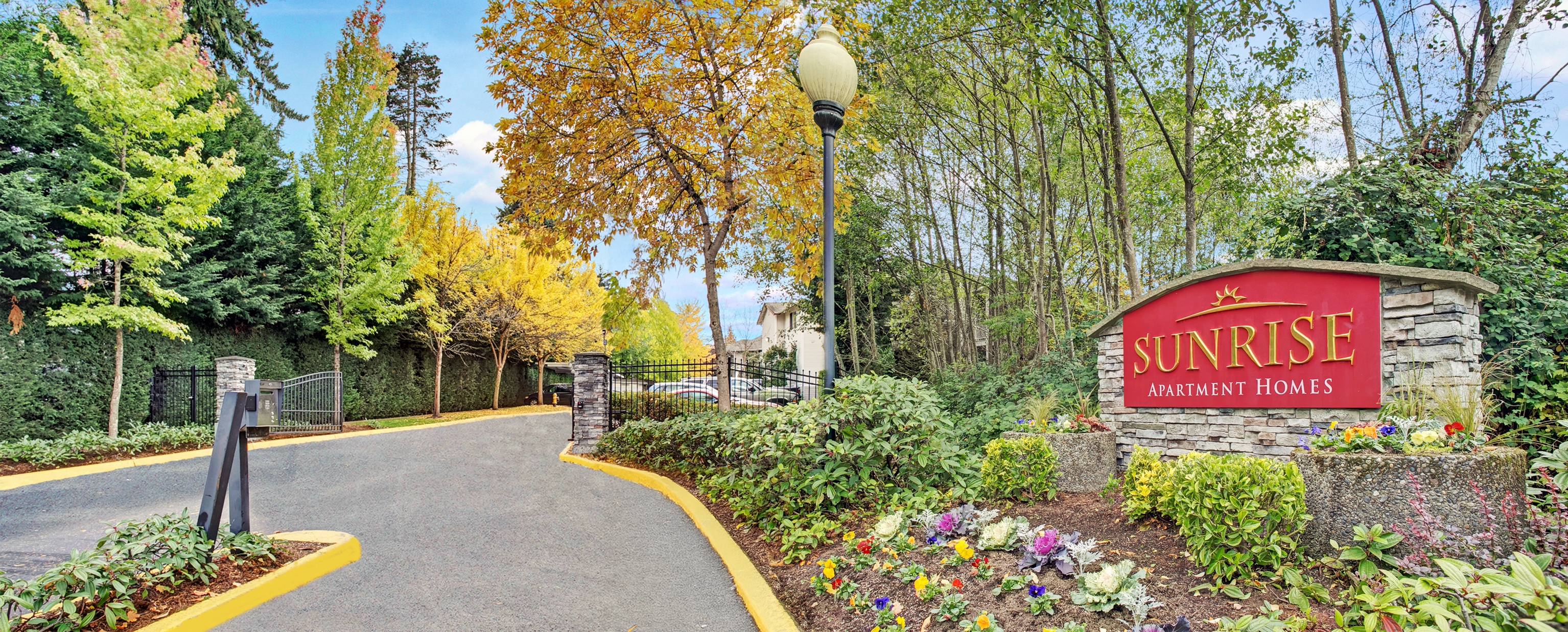 Banner image with entry sign and landscaping at Sunrise Lane Apartments in Everett WA