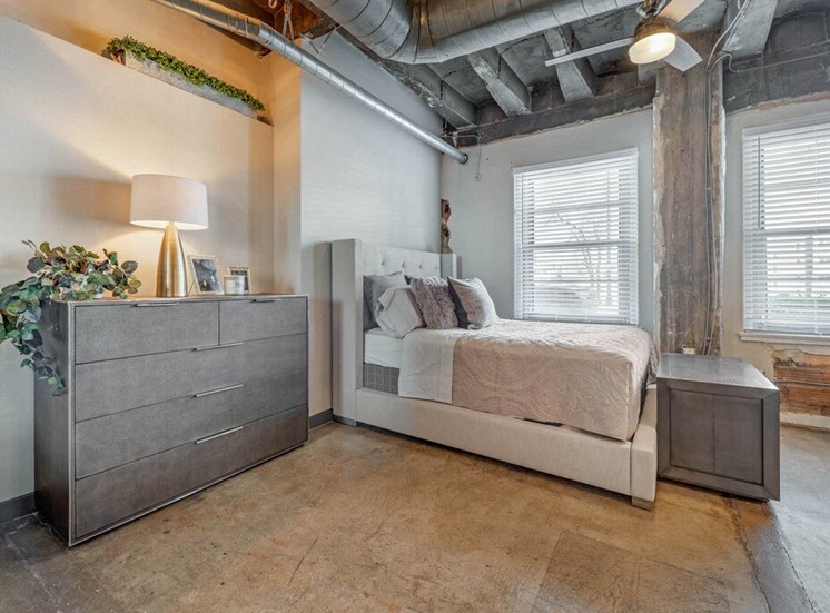 Industrial Style Apartment  with Exposed Ducts and Concrete, with Dresser, Bed , Chest , Decorations and Decorative Plants Next to Windows