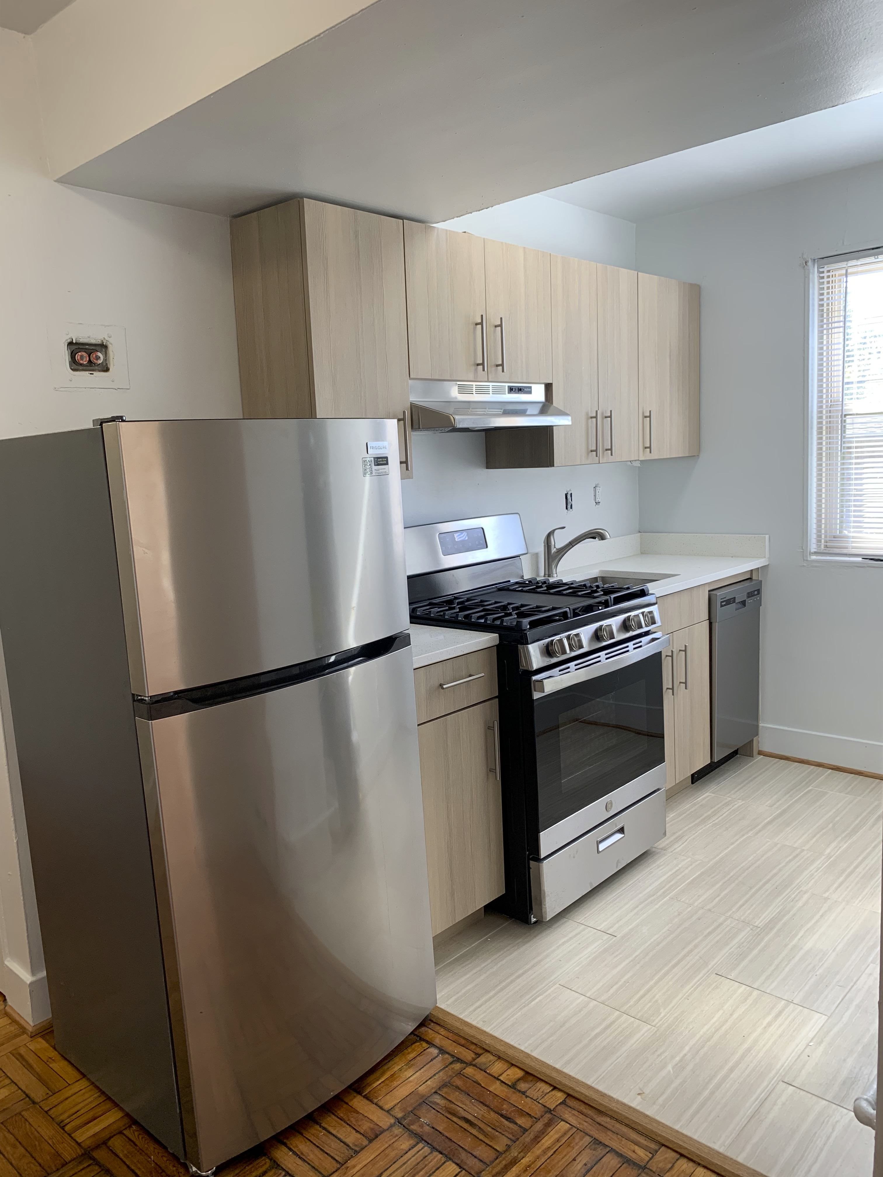 A modern kitchen with a stainless steel refrigerator and stove.