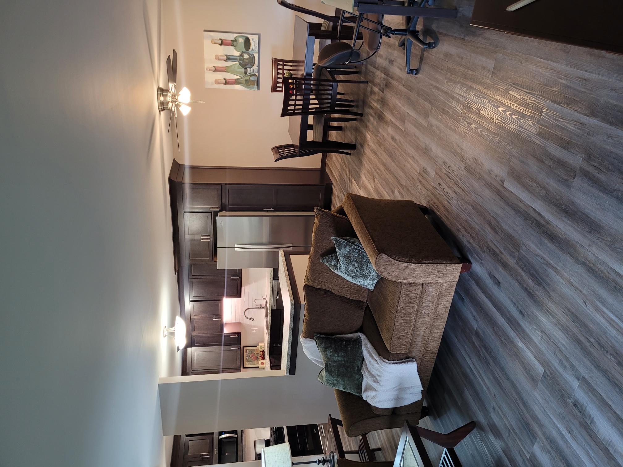 A modern kitchen with a wooden wall and a staircase.