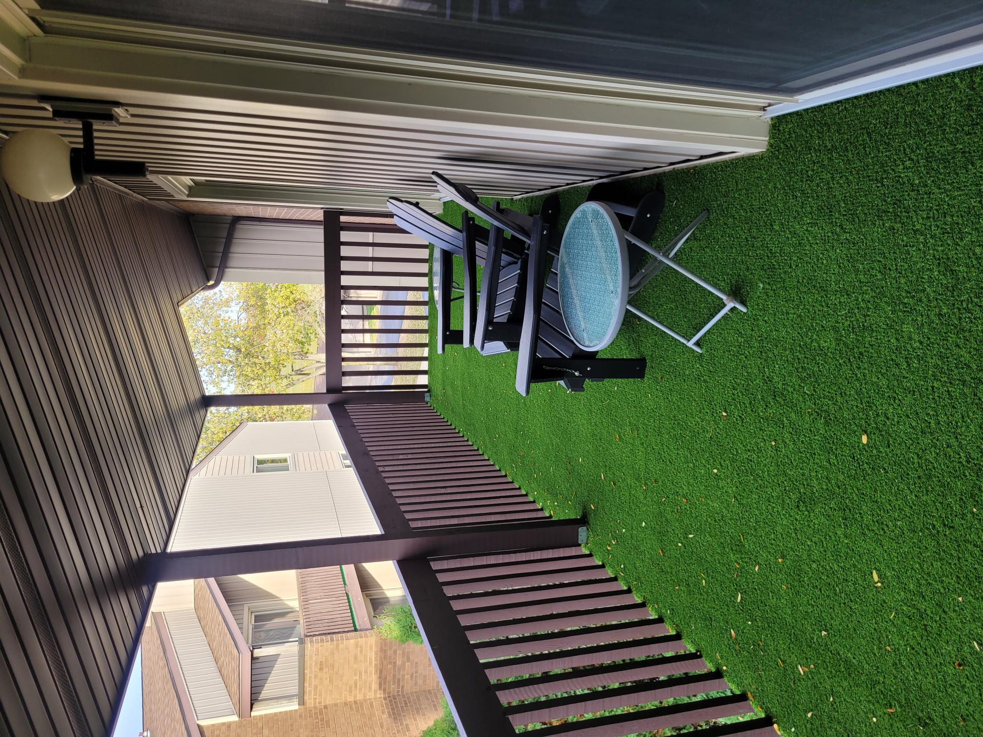 A patio with a lawn chair and a table is visible from an elevated viewpoint.