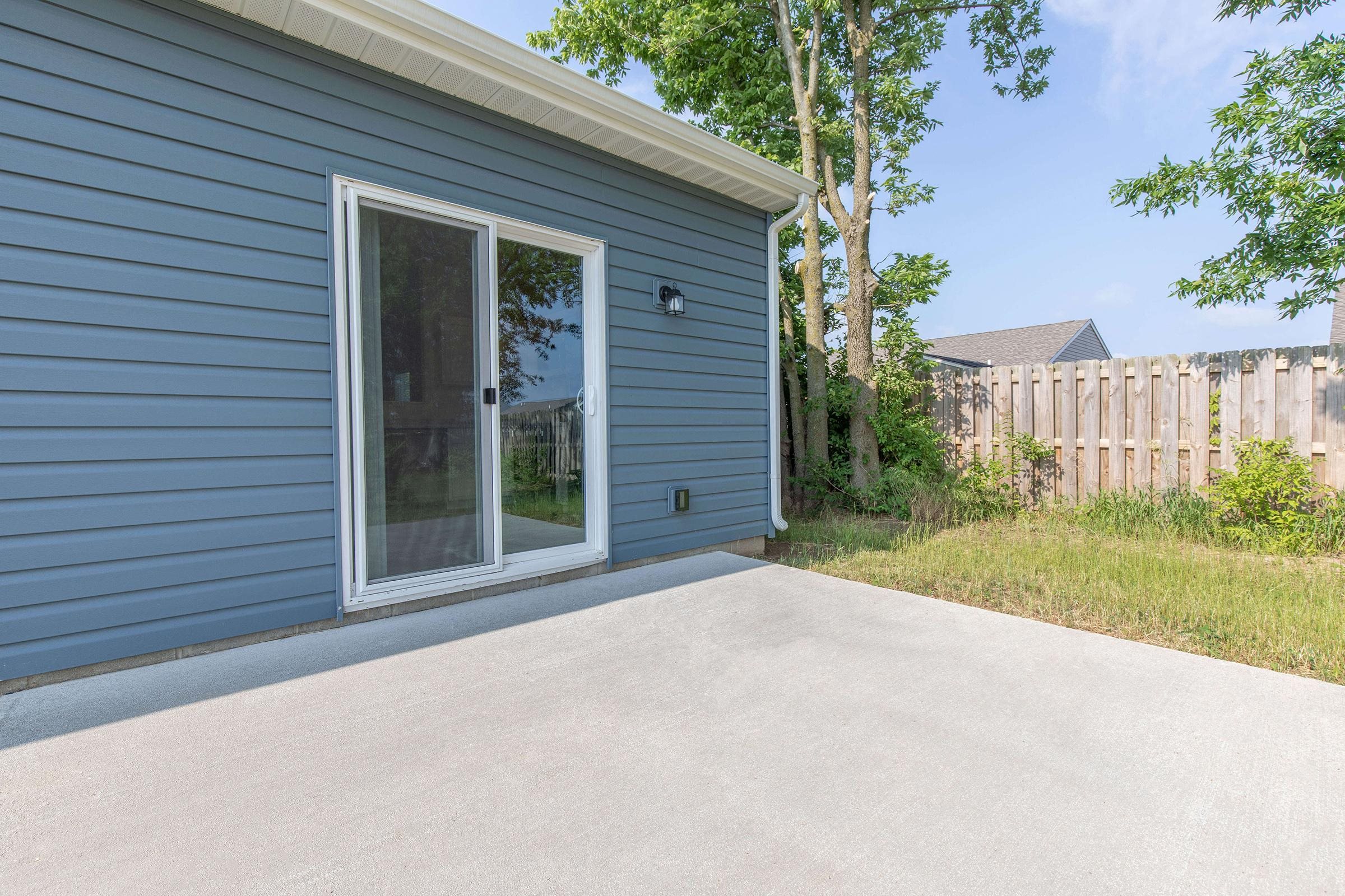 a patio in front of a blue house