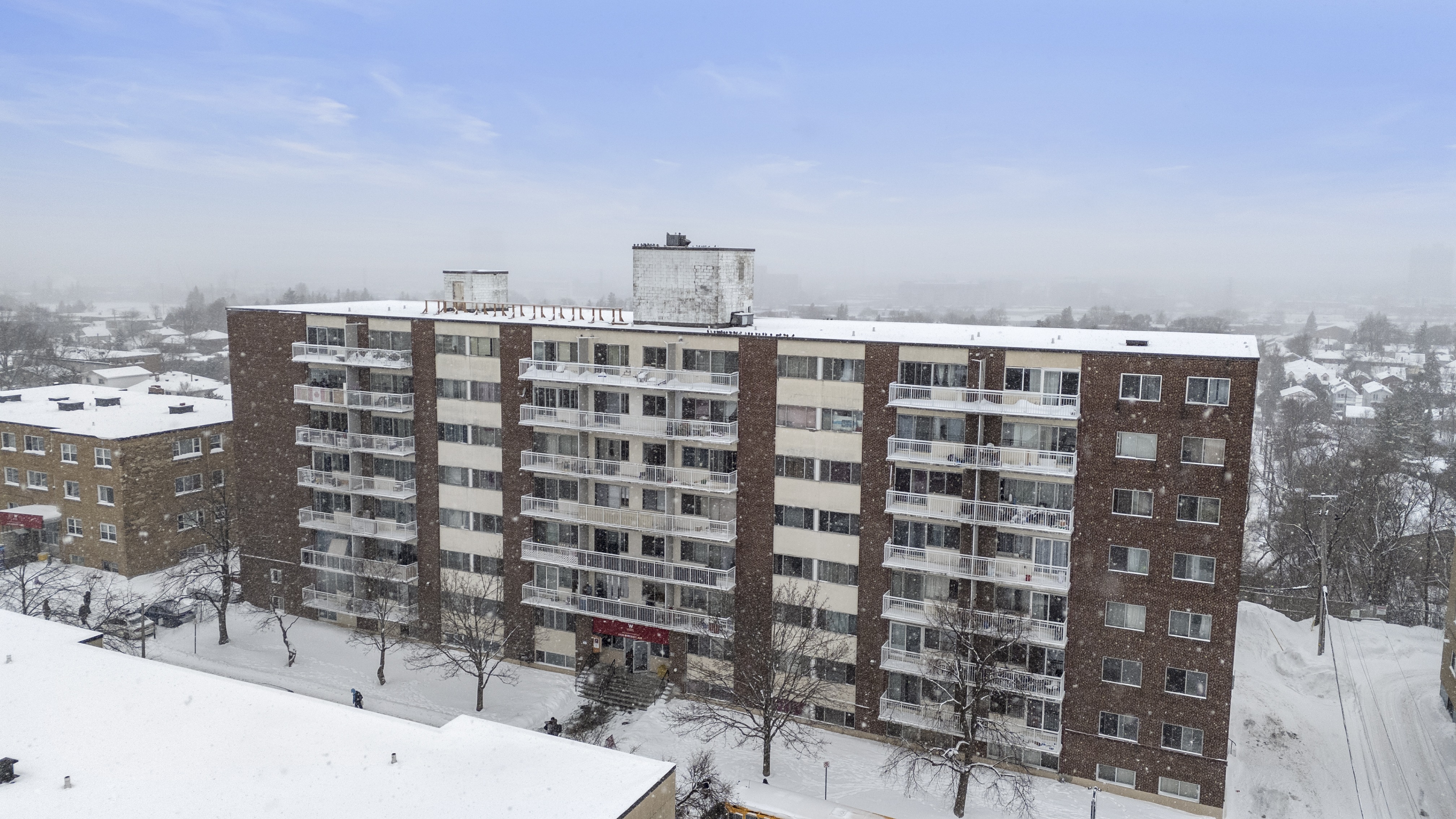 A large building with a lot of windows covered in snow.