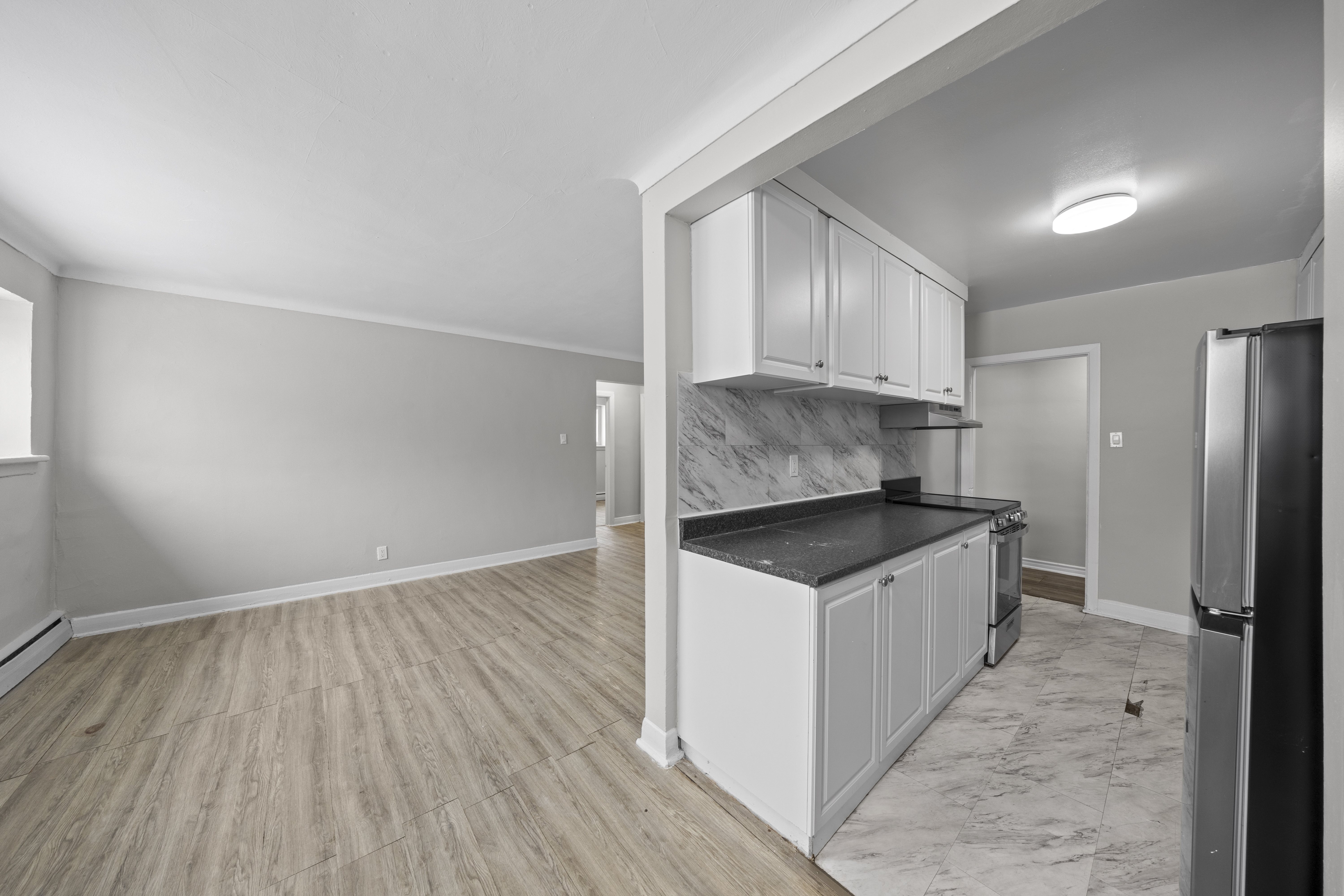 A kitchen with a refrigerator, cabinets, and a countertop.
