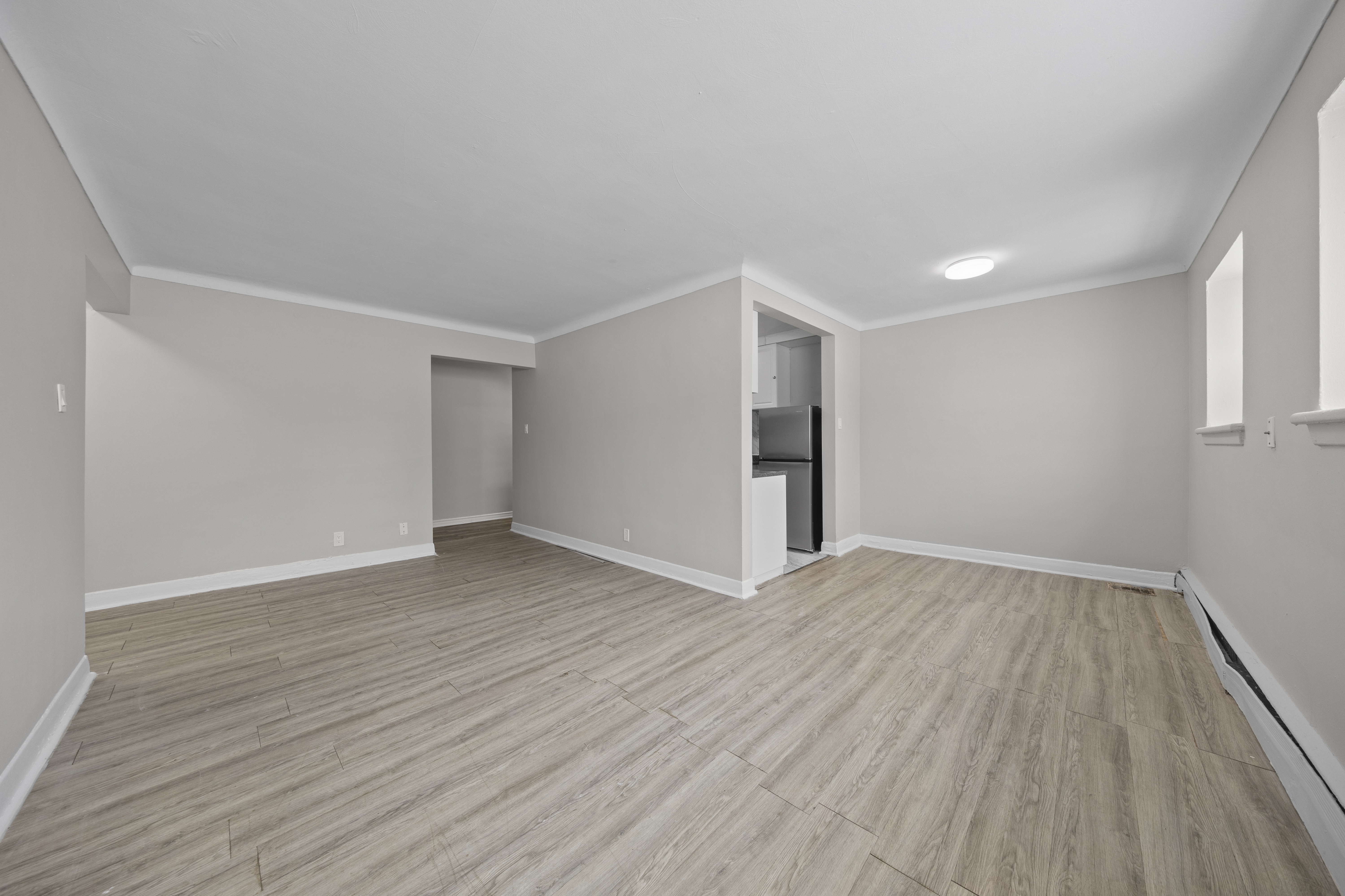 A room with wooden flooring and white walls.