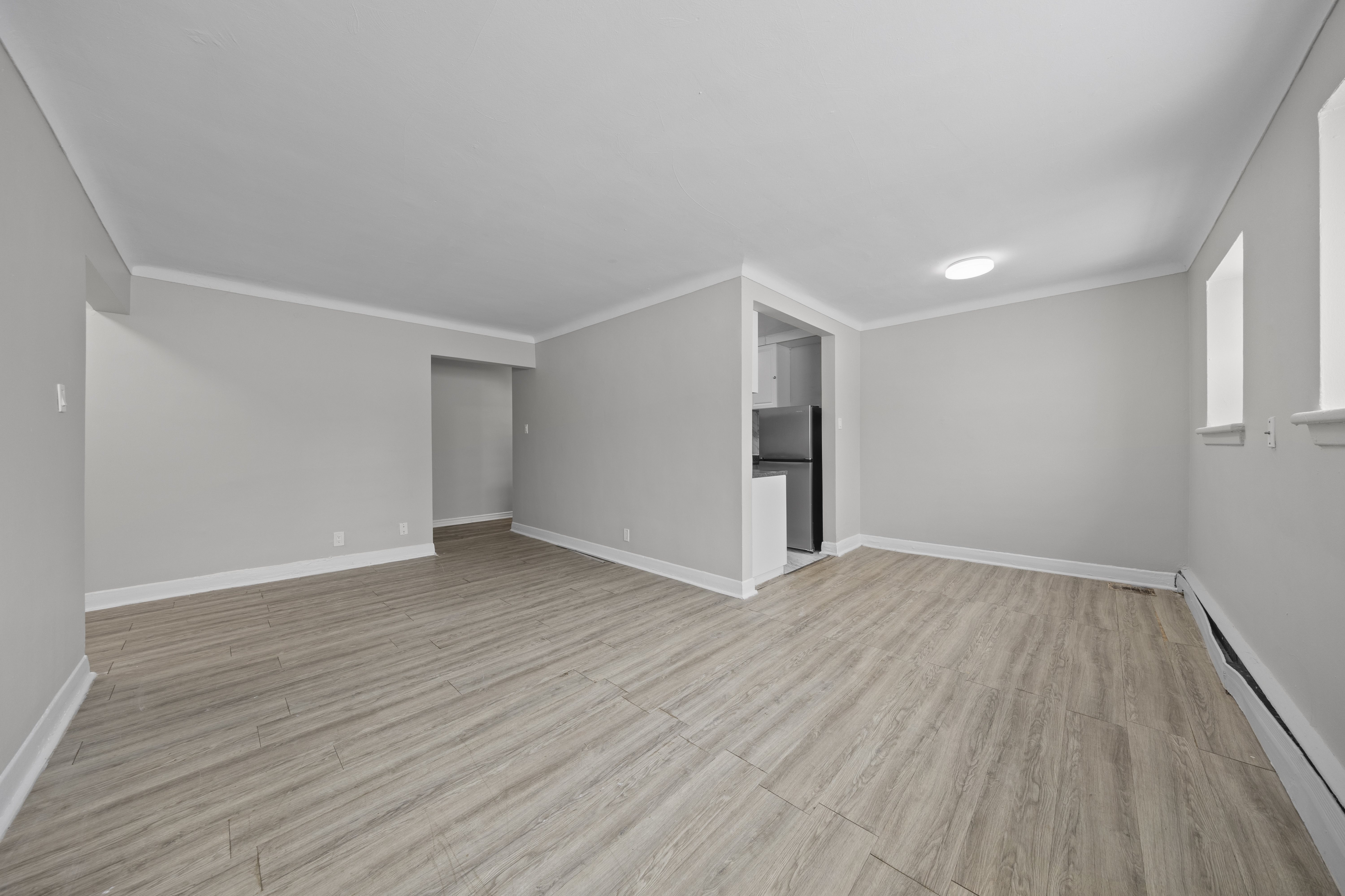 A room with wooden flooring and white walls.