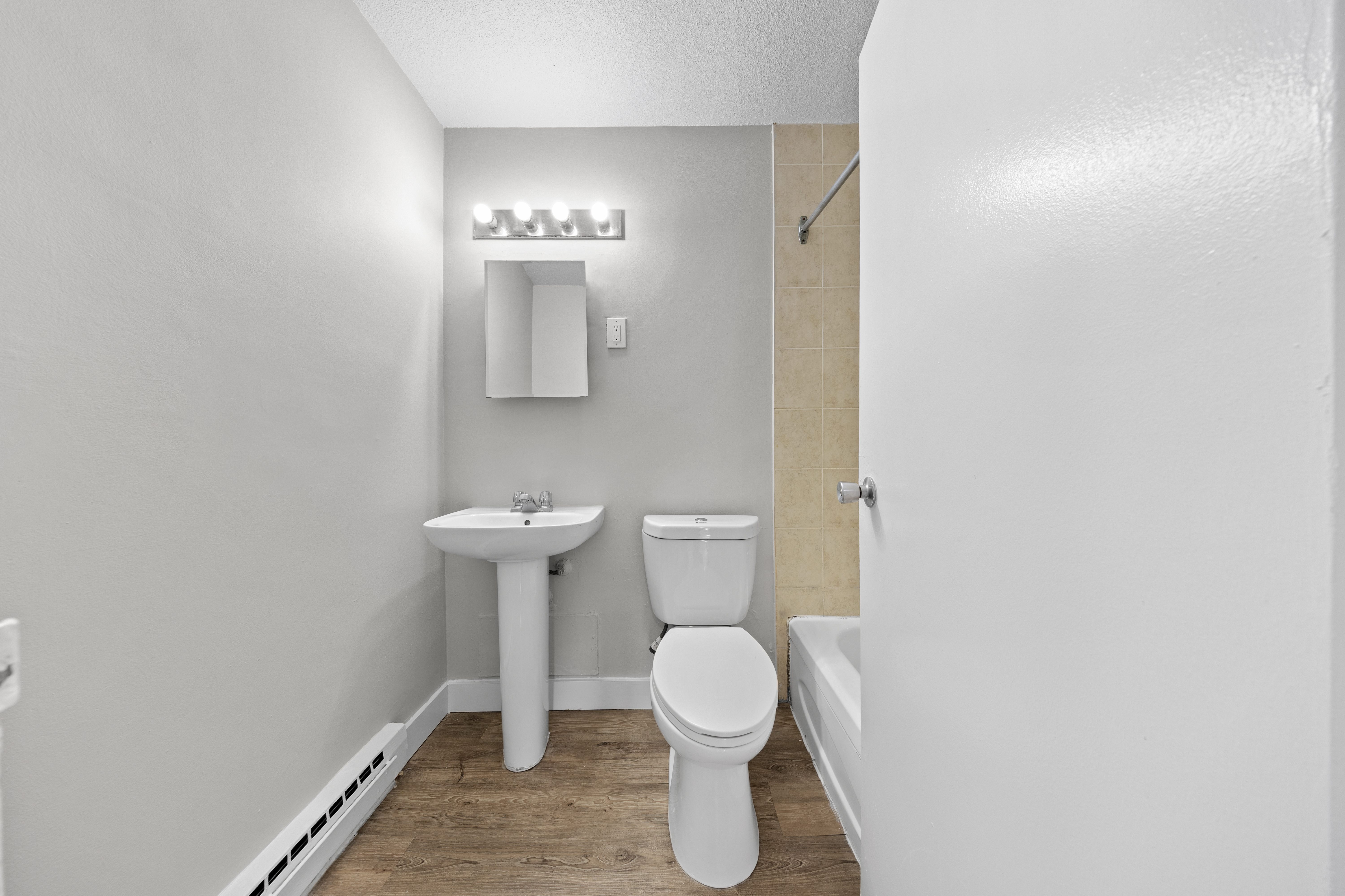 A white toilet sits next to a sink in a small bathroom.