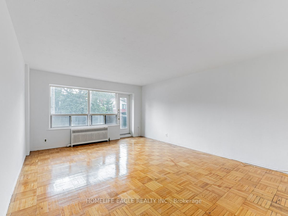 a living room with a wood floor and a large window