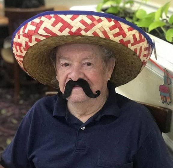Senior Poses With A Hat and Mustache at Savannah Cottage of Lakeland, Lakeland, FL, 33809