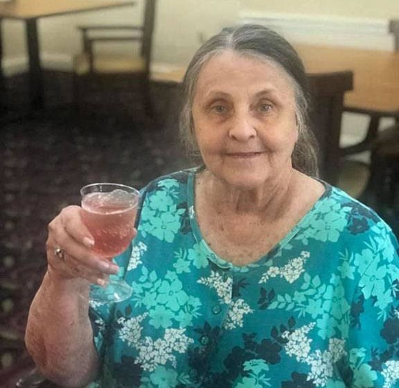Senior Resident Poses With A Drink at Savannah Court of Brandon, Florida