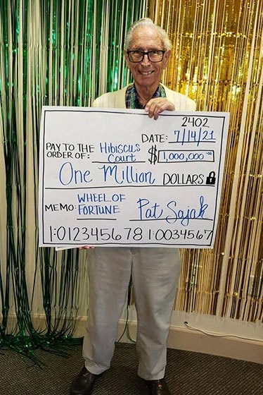 Senior Is Taking A Photo With A Cheque at Hibiscus Court, Florida, 32901