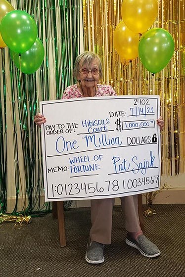 Senior Lady Poses With A Cheque at Hibiscus Court, Melbourne, FL