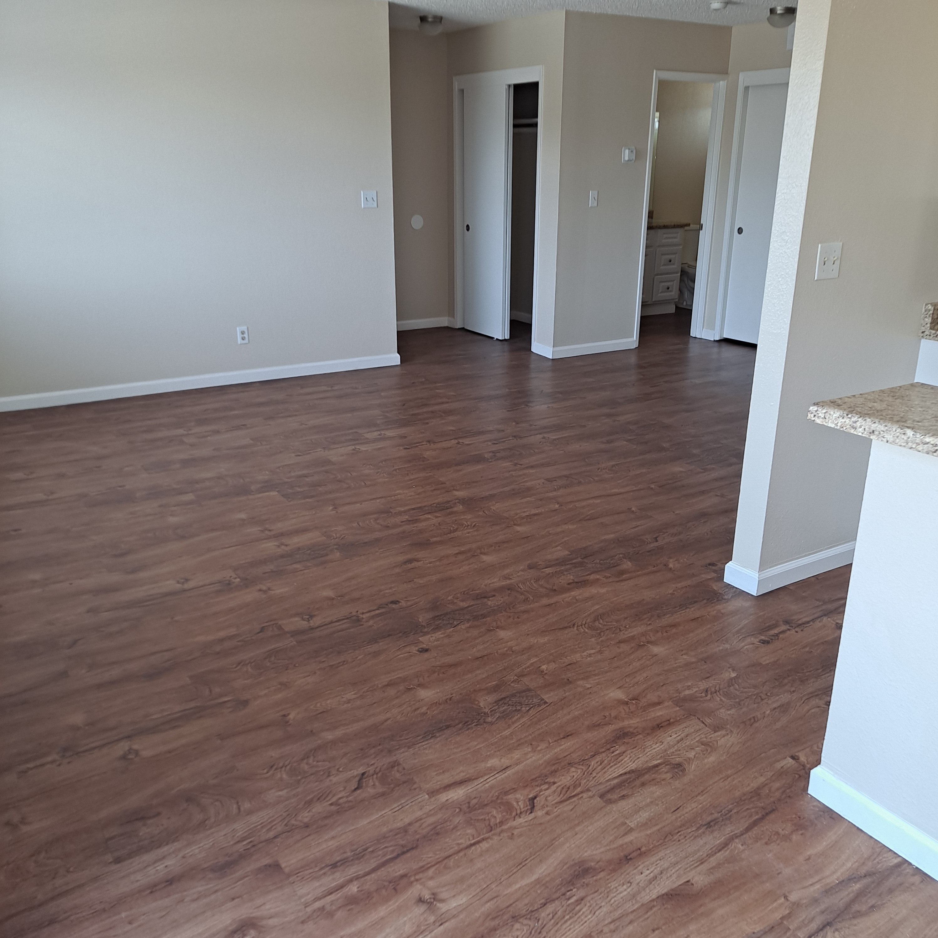 A room with wood flooring and white walls.