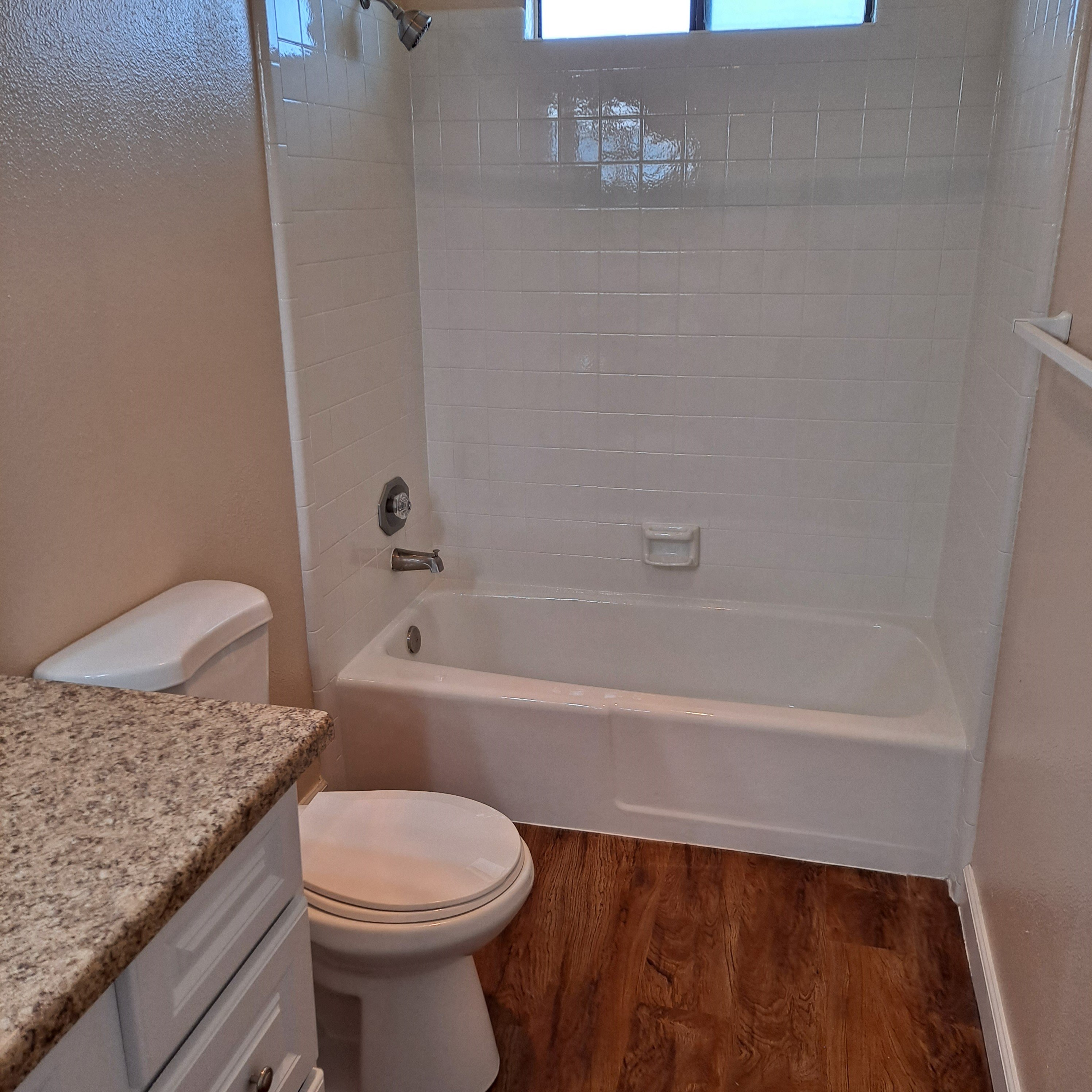 A white toilet sits next to a bathtub in a bathroom.
