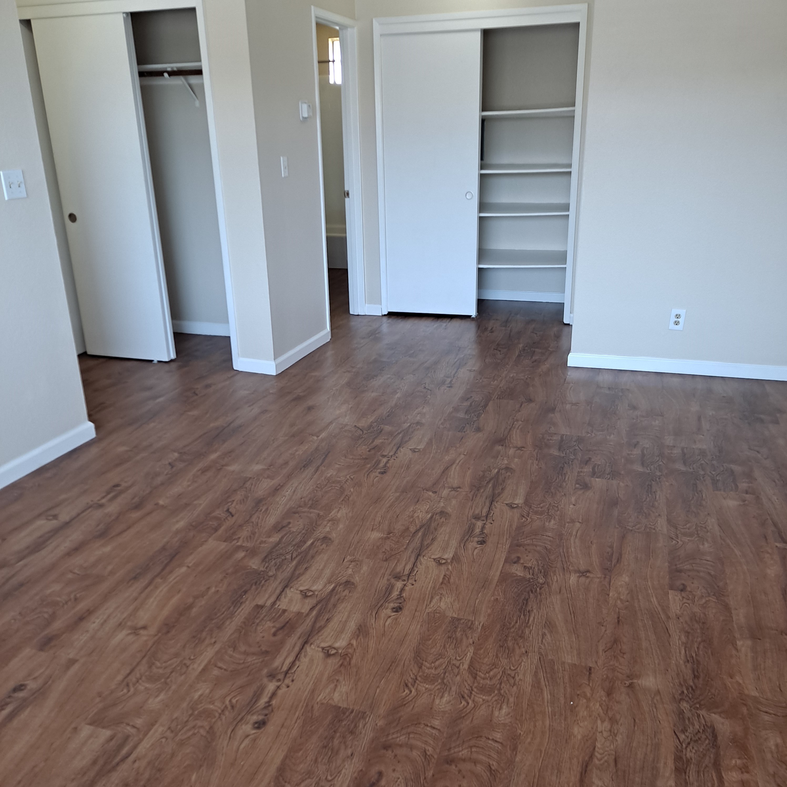 A room with wood flooring and white walls.