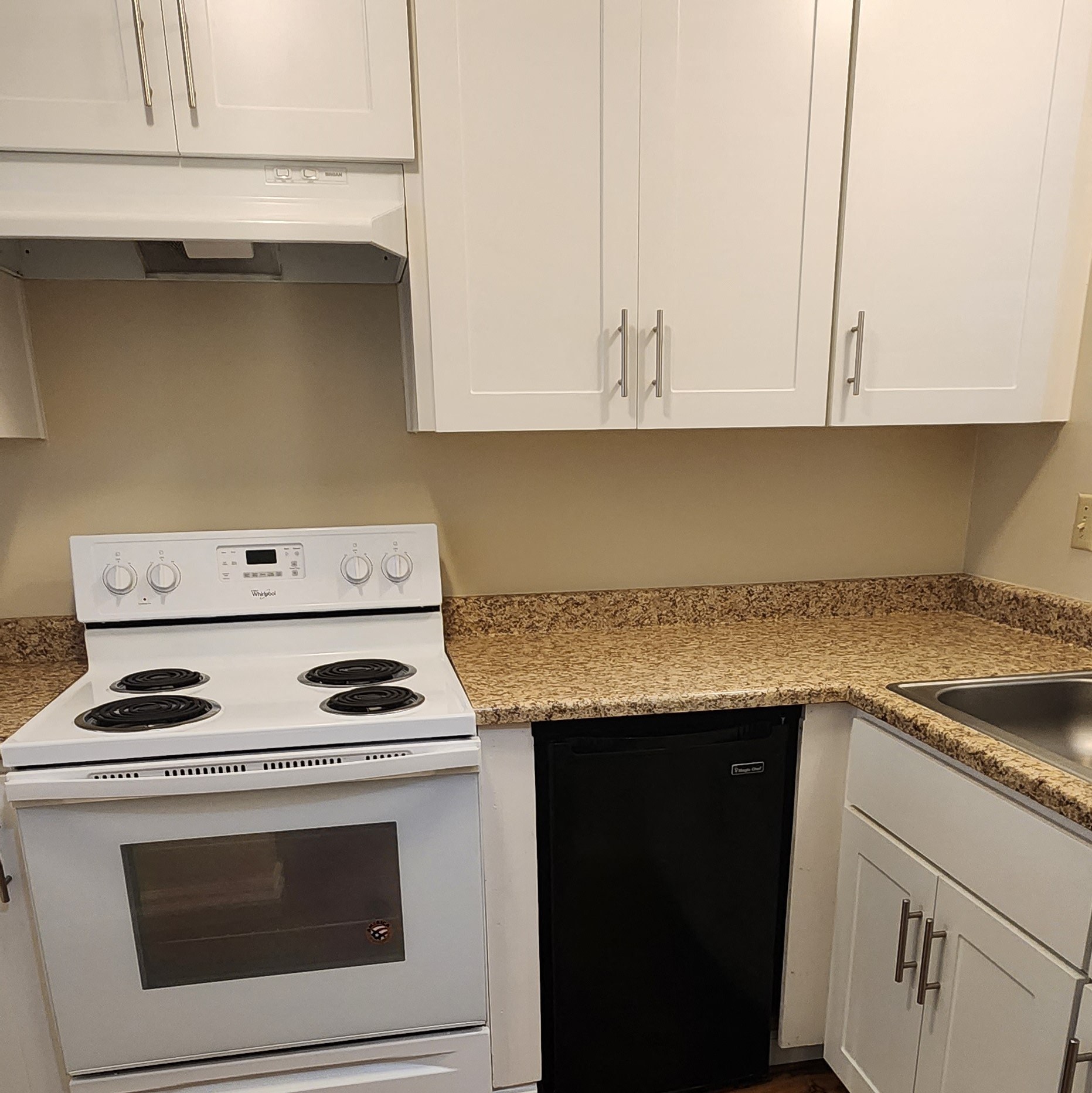 a kitchen with white appliances and a counter top and white cabinets