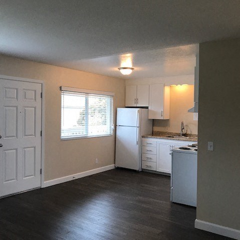 an empty kitchen with a refrigerator and a sink