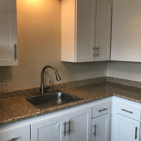 a kitchen with white cabinets and a sink