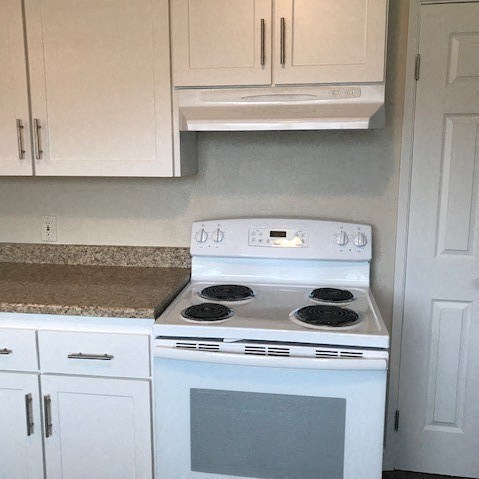 a kitchen with white cabinets and a counter top