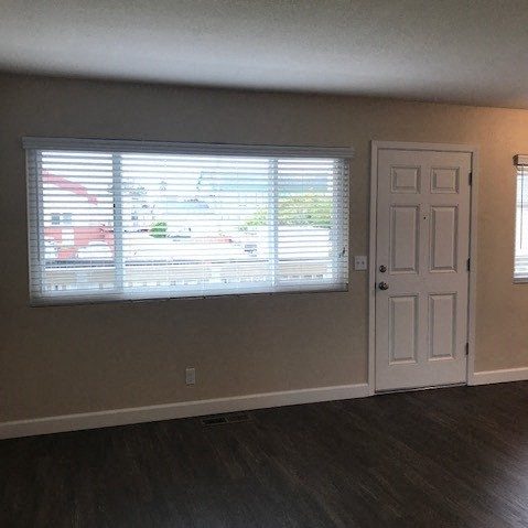 an empty living room with a window and a door