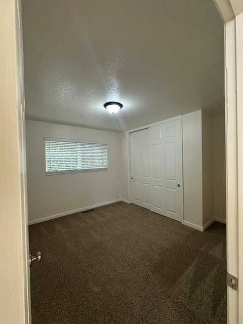 A room with a carpeted floor and a white door.