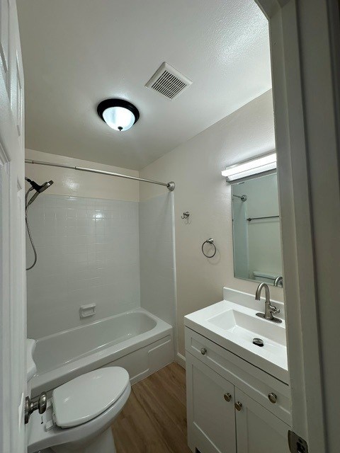 A white bathroom with a toilet, sink, and shower.