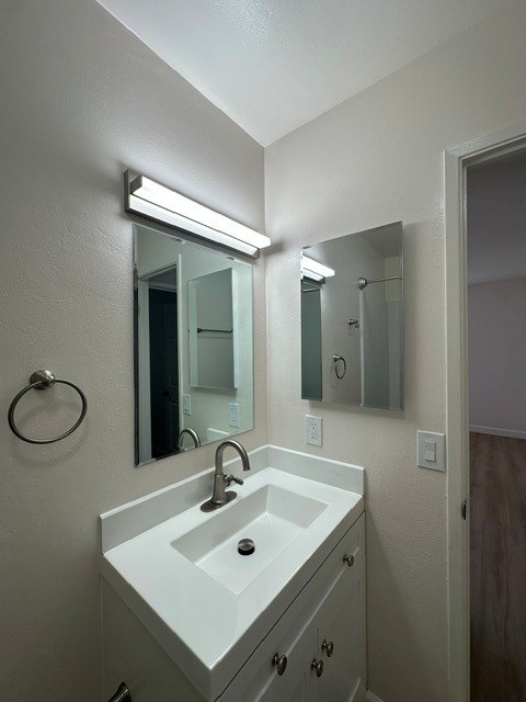 A bathroom with a white sink and a mirror above it.