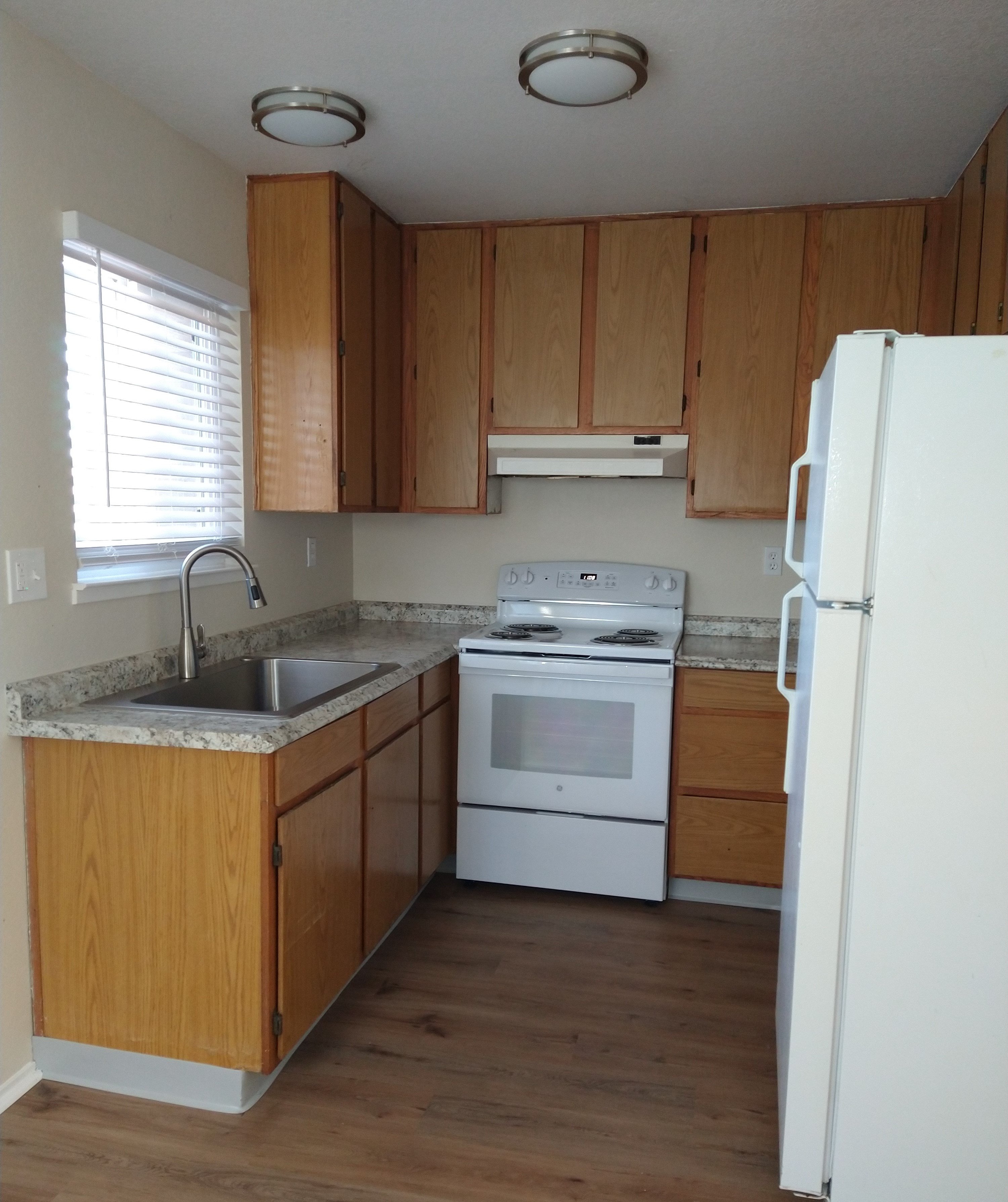 A kitchen with wooden cabinets and white appliances.