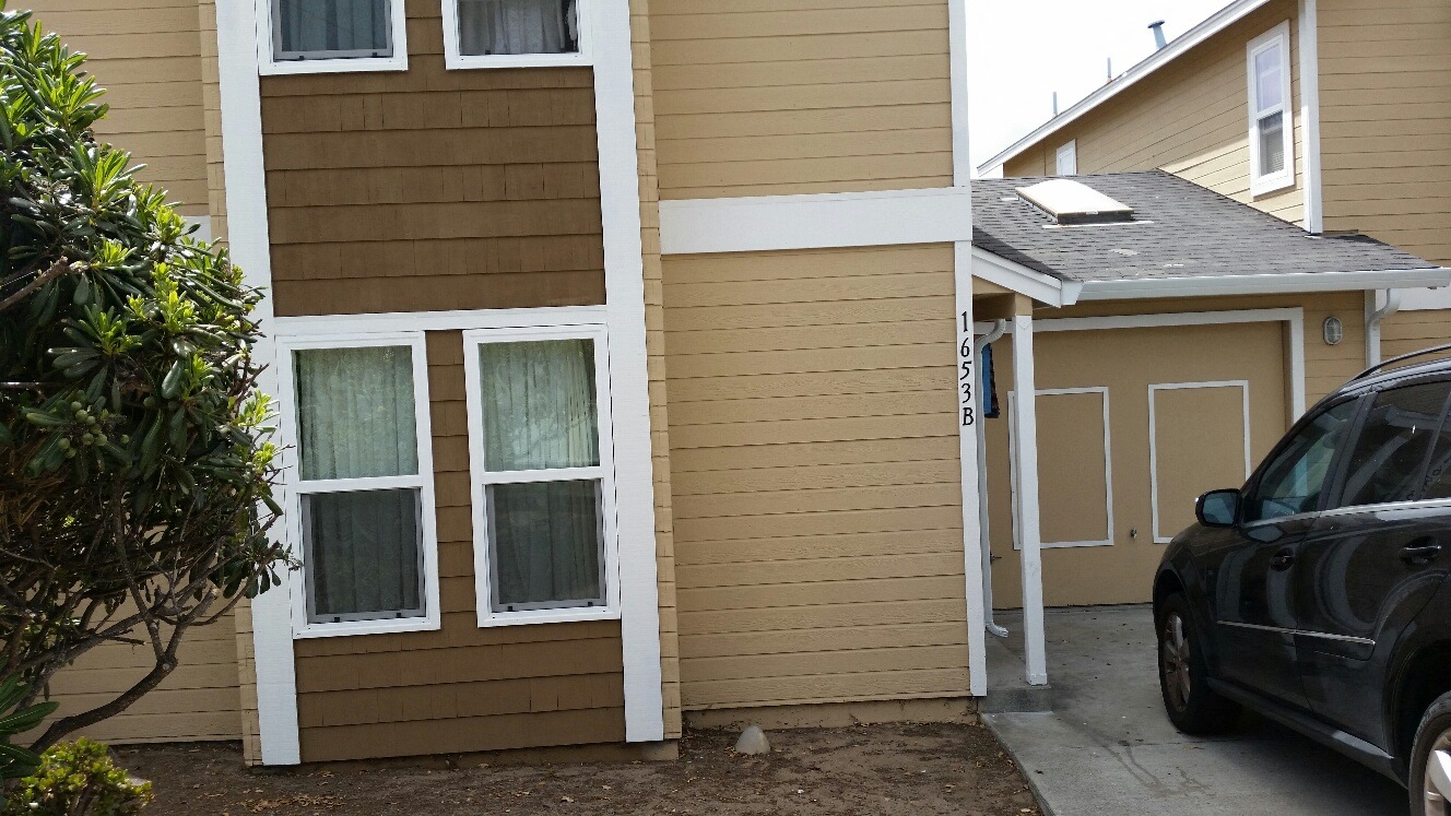 a side view of a house with a car parked outside