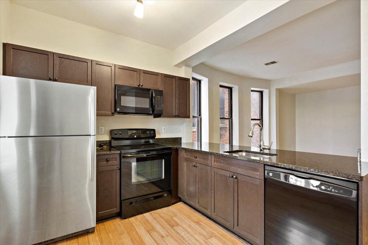 a kitchen with wooden cabinets and stainless steel appliances