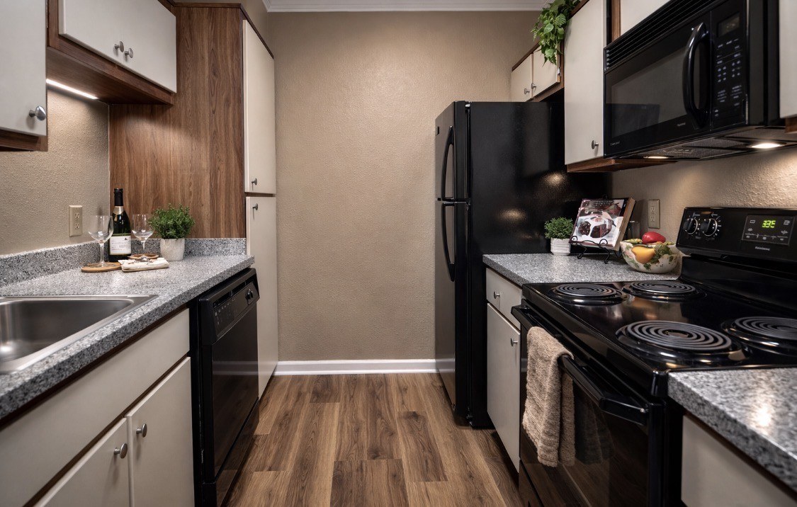 A kitchen with black appliances and wooden cabinets.