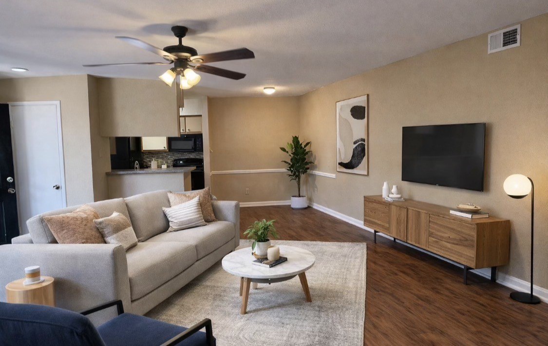 A living room with a couch, a coffee table, and a ceiling fan.