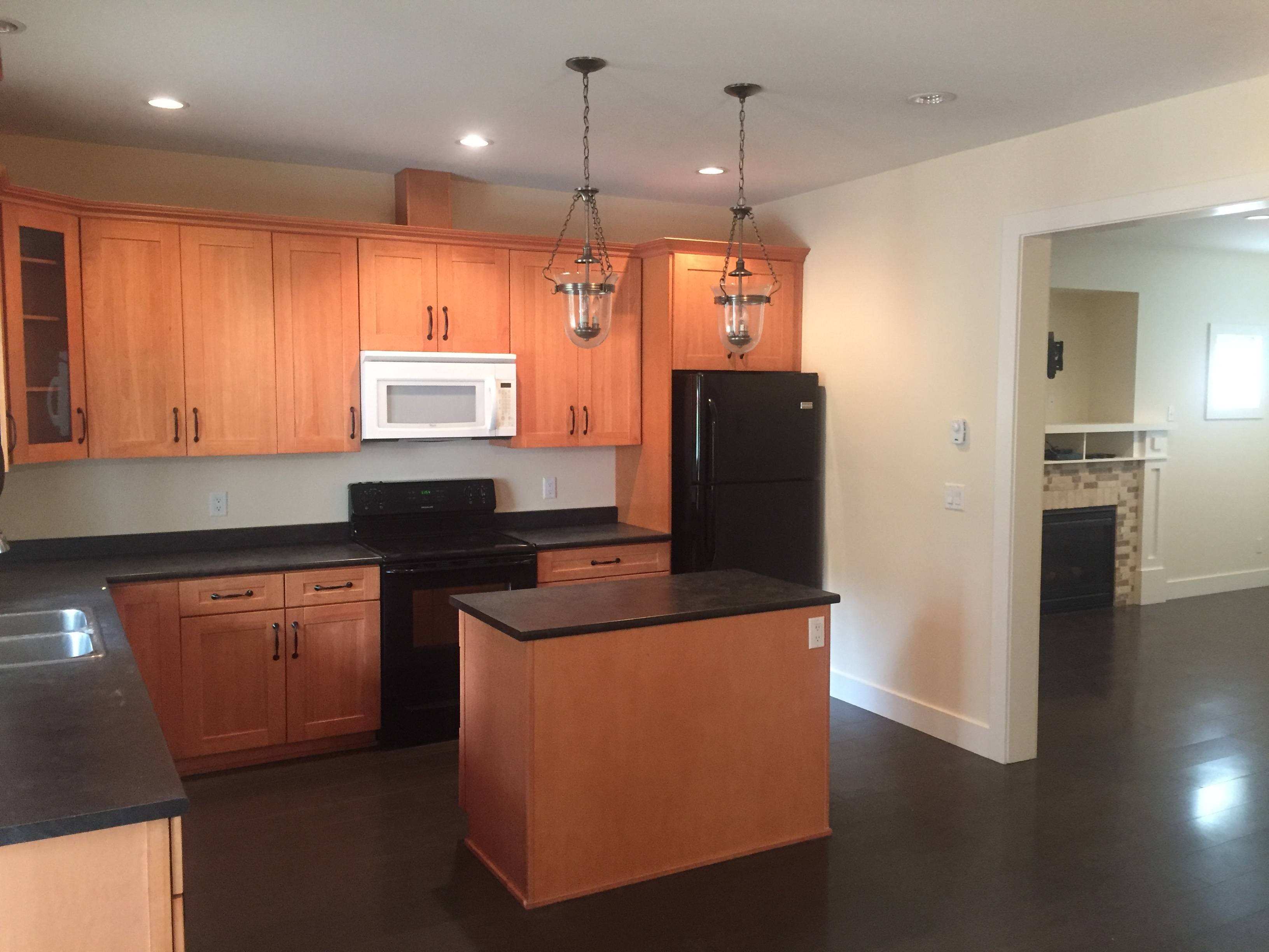 A kitchen with wooden cabinets and black appliances.