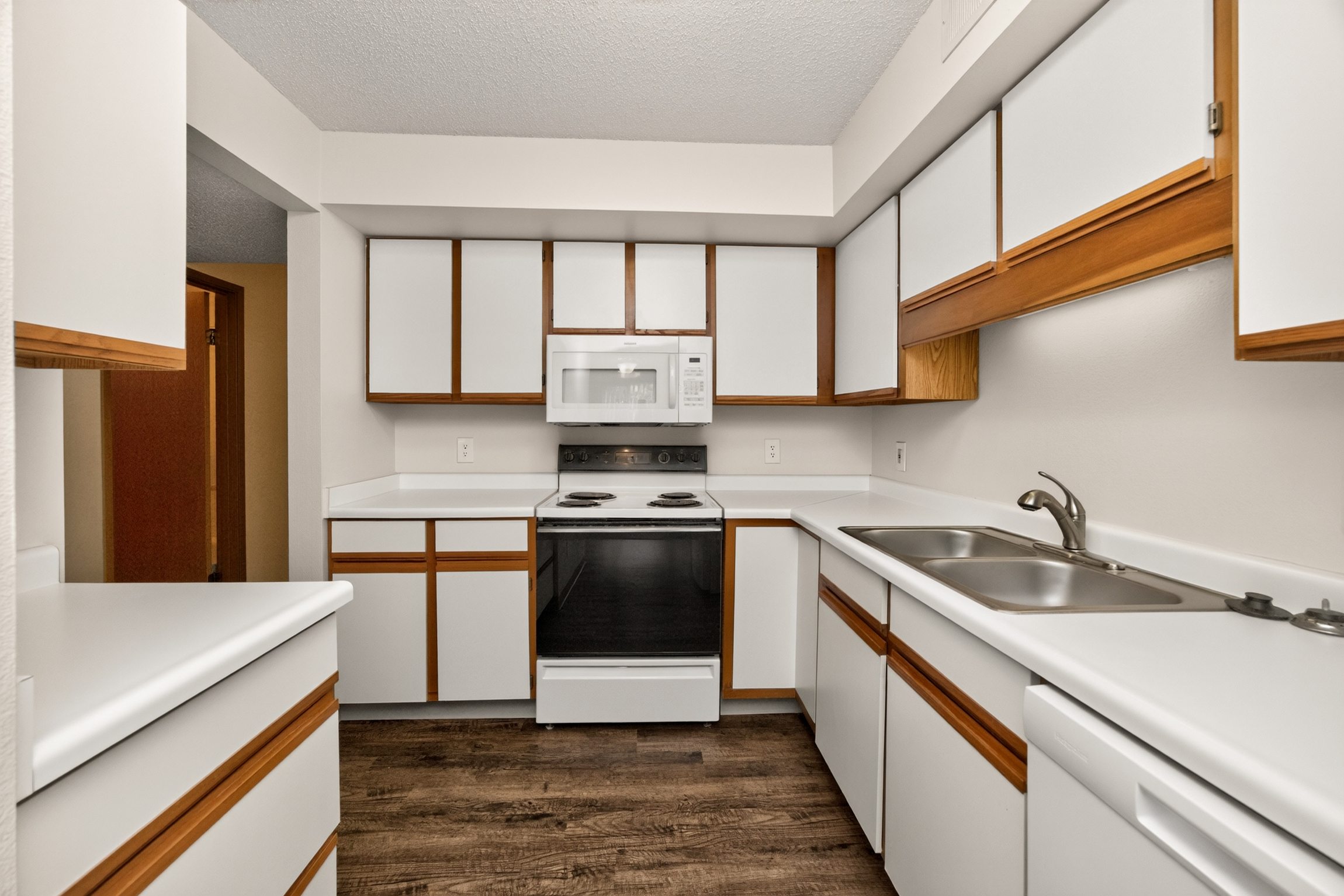 A kitchen with white cabinets and a black oven.